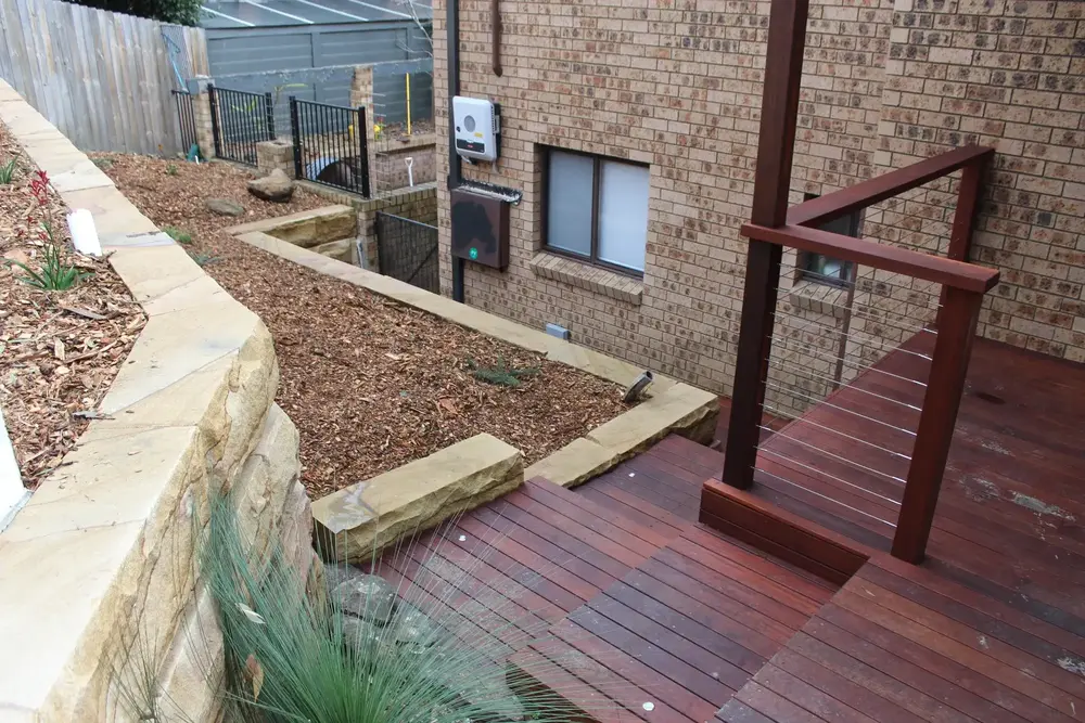 Sandstone block retaining walls and mulched native garden beds in a Blaxland front yard