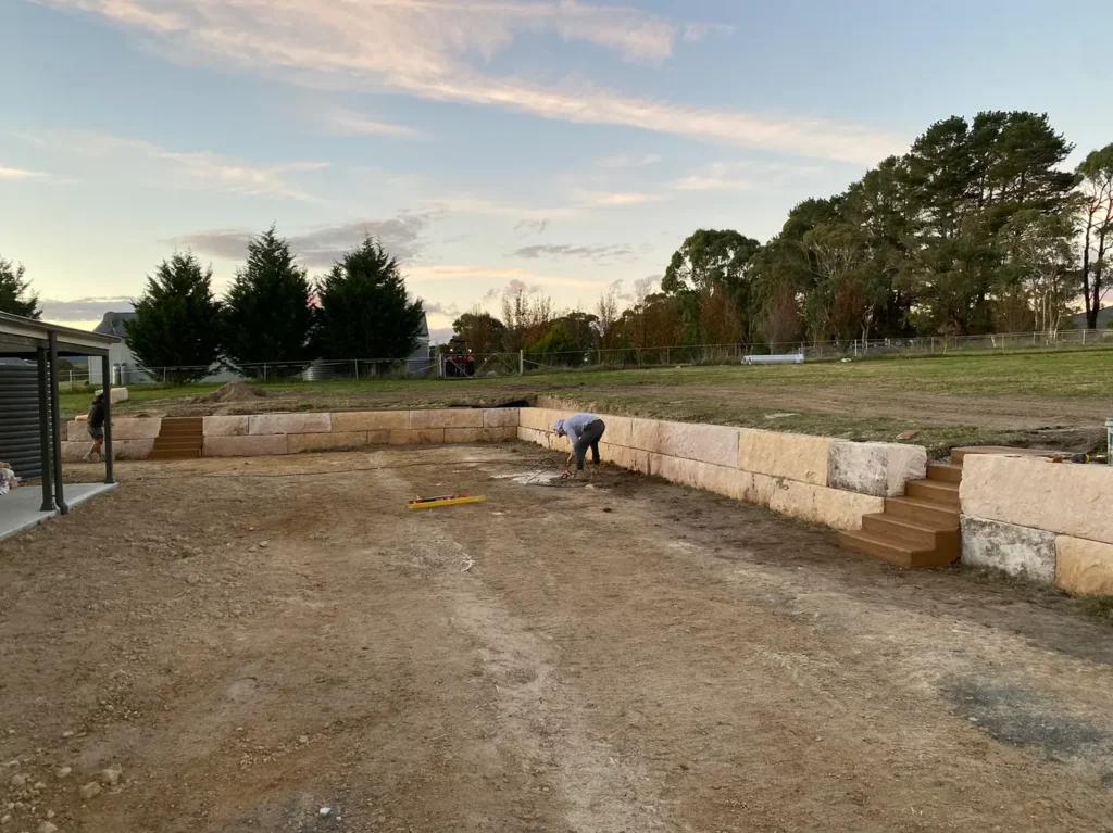 Sandstone log retaining wall around a levelled area at Duckmaloi